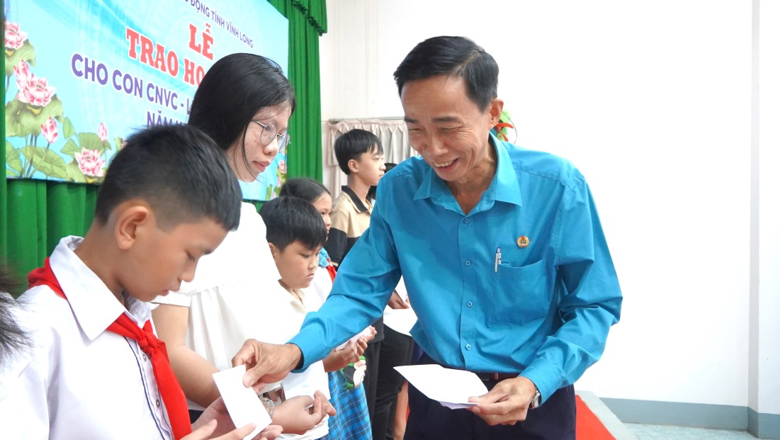 Chủ tịch LĐLĐ tỉnh Vĩnh Long Trần Văn Trạch trao học bổng cho các em học sinh. Ảnh: Tạ Quang