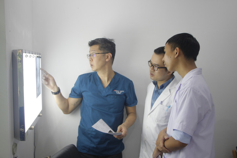 Thạc sĩ-Bác sĩ Đỗ Văn Hiếu (giữa) cùng chuyên gia y tế Singapore thảo luận trường hợp sỏi tiết niệu cho một bệnh nhân. Ảnh: Sông Hàn