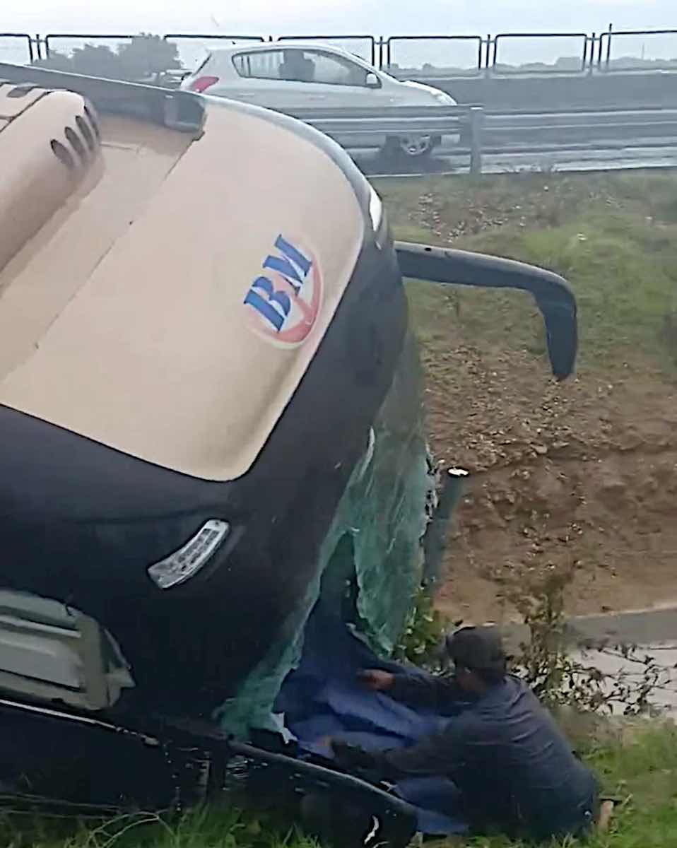 Người dân đập kính để hành khách kẹt bên trong xe ra ngoài. Ảnh: Duy Tuấn