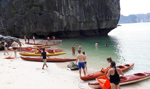 Du khách chèo kayak vào một bãi tắm trên vịnh Lan Hạ. Ảnh: Nguyễn Hùng