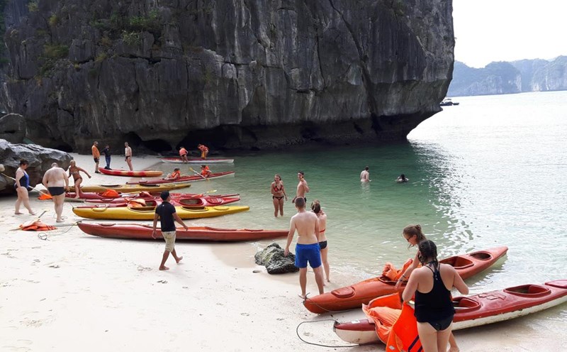 Du khách chèo kayak vào một bãi tắm trên vịnh Lan Hạ. Ảnh: Nguyễn Hùng