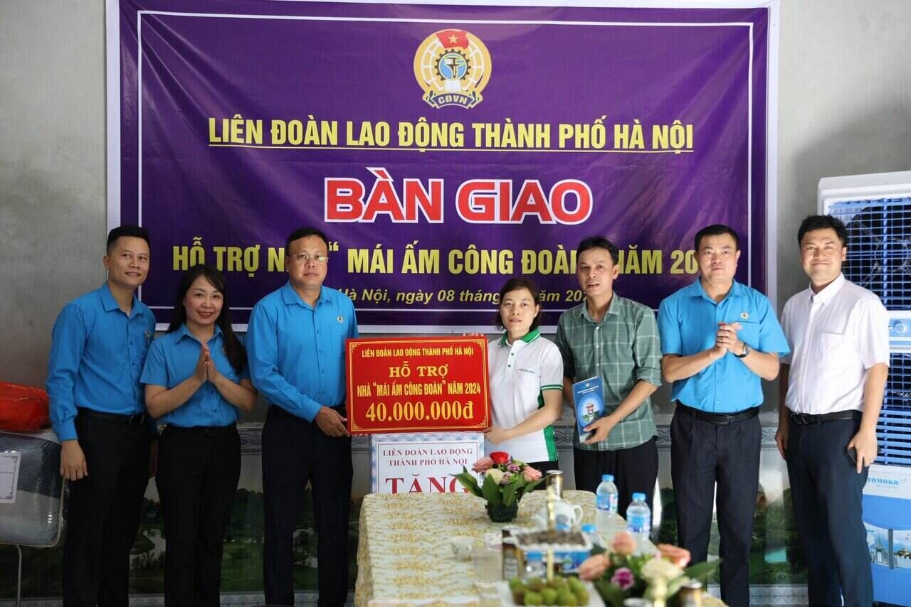 Ông Phạm Quang Thanh - Chủ tịch LĐLĐ Thành phố Hà Nội (thứ ba từ trái sang) trao kinh phí Mái ấm Công đoàn cho chị Lê Thị Tươi