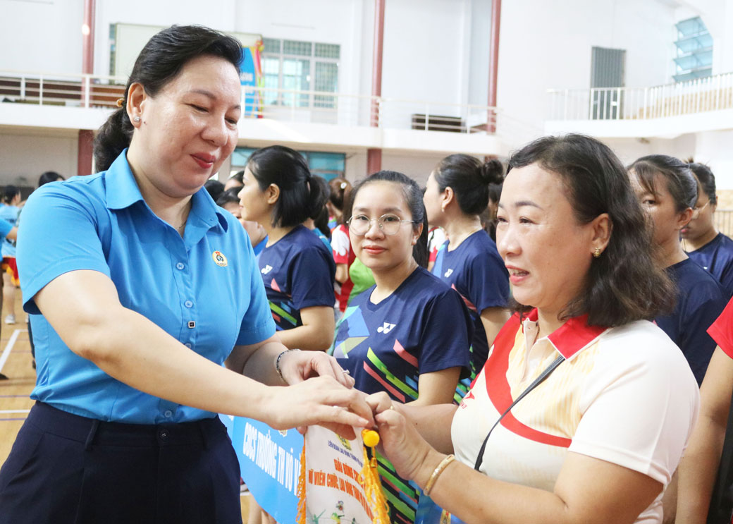 Chủ tịch LĐLĐ thành phố Quy Nhơn tặng cờ lưu niệm cho các đội. Ảnh: Mai Thảo.