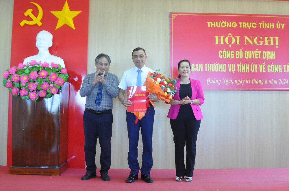 Bà Đinh Thị Hồng Minh - Phó Bí thư Tỉnh ủy Quảng Ngãi và ông Lữ Ngọc Bình - Trưởng Ban Tổ chức Tỉnh ủy - trao quyết định và tặng hoa cho ông Trần Đại Thắng (giữa). Ảnh: Viên Nguyễn