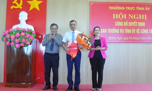 Bà Đinh Thị Hồng Minh - Phó Bí thư Tỉnh ủy Quảng Ngãi và ông Lữ Ngọc Bình - Trưởng Ban Tổ chức Tỉnh ủy - trao quyết định và tặng hoa cho ông Trần Đại Thắng (giữa). Ảnh: Viên Nguyễn
