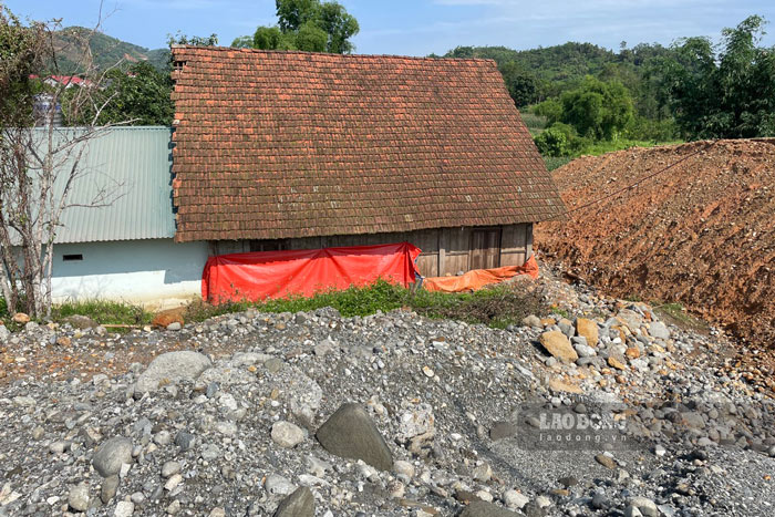 After the flooding caused by the high road discharging water into houses, many families had to set up a tarpaulin behind their houses to prevent water from entering. Photo: Đinh Đại