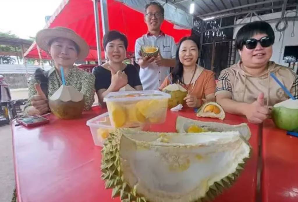 Chinese tourists satisfy their durian cravings at a fruit stall in Melaka. Photo: The Star