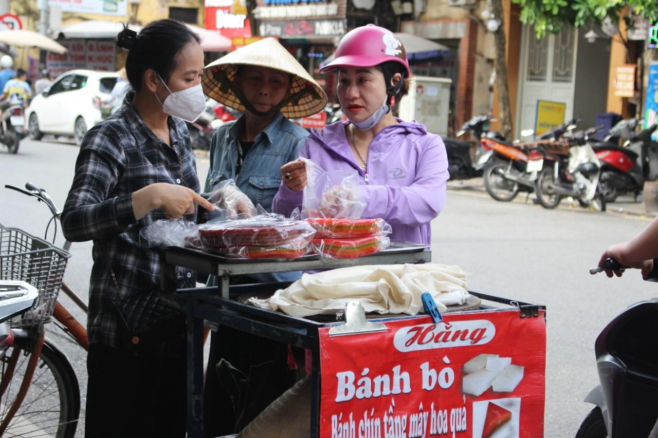 Chị Hằng (áo kẻ) đẩy xe bánh bò đi quanh khu vực phố cổ buổi chiều từ khoảng 14 giờ 30 phút đến 18 giờ. Ảnh: Thạch Lựu