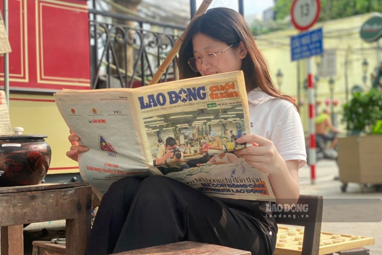 Đọc báo tại khu trưng bày "Toa Bao cấp: Bếp - Chạn - Mâm".