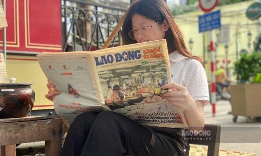 Đọc báo tại khu trưng bày "Toa Bao cấp: Bếp - Chạn - Mâm".
