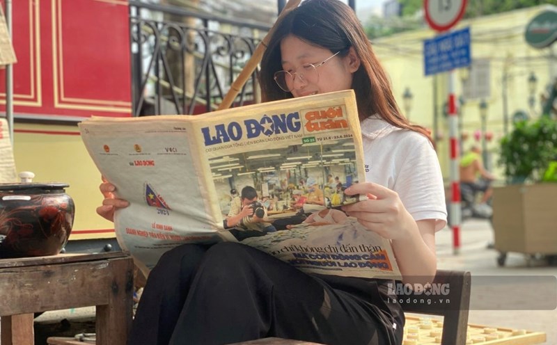 Đọc báo tại khu trưng bày "Toa Bao cấp: Bếp - Chạn - Mâm".