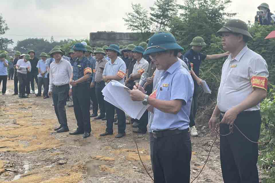 Lãnh đạo UBND xã Hồng Minh đọc quyết định cưỡng chế thu hồi đất theo quy định. Ảnh: Trường Nguyễn