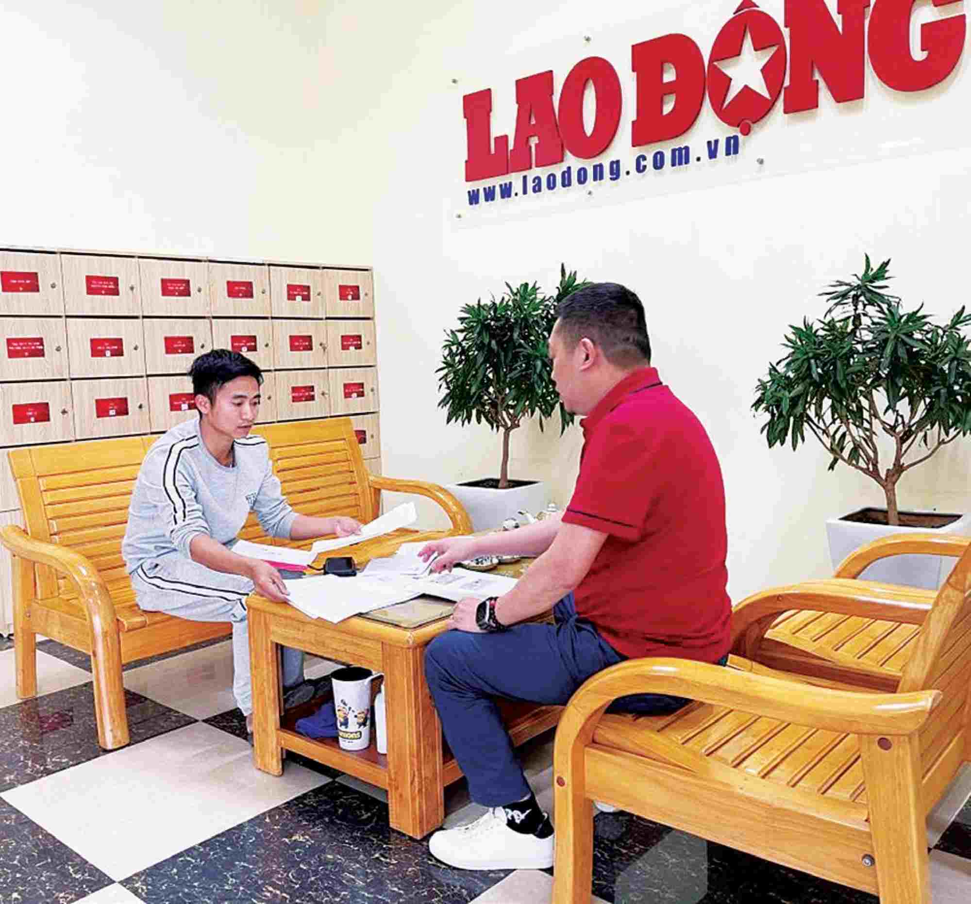 Lao Dong Newspaper reporter (right) receives files from workers whose legal and legitimate rights have been violated. Photo: VIET LAM