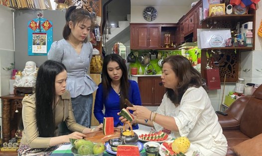 Bà Nguyễn Thị Hằng hướng dẫn các con cách gọt, tỉa trái cây theo phong cách của gia đình Việt. Ảnh: Minh Tâm