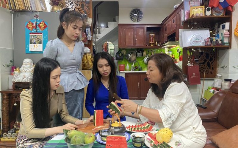 Bà Nguyễn Thị Hằng hướng dẫn các con cách gọt, tỉa trái cây theo phong cách của gia đình Việt. Ảnh: Minh Tâm