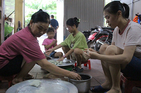 Bà Thềm (bên trái) cùng gia đình làm bánh khúc.