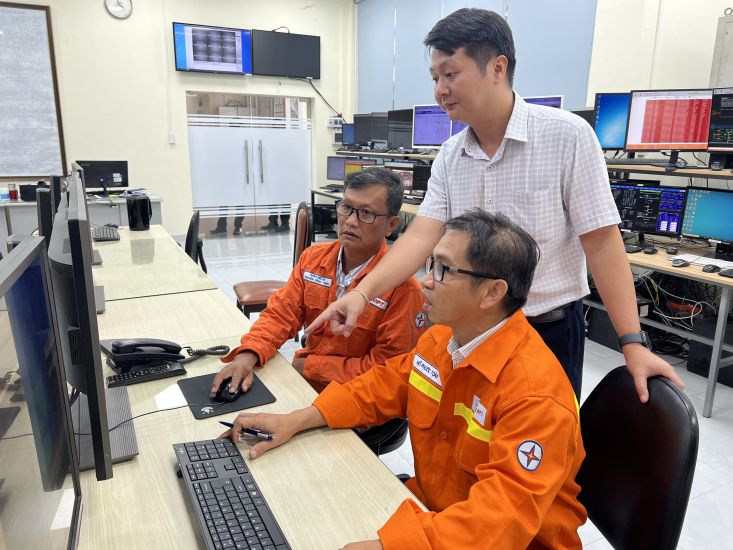 Ông Võ Sỹ Danh (người đứng) hướng dẫn công nhân theo dõi truyền tải điện. Ảnh: Đức Long