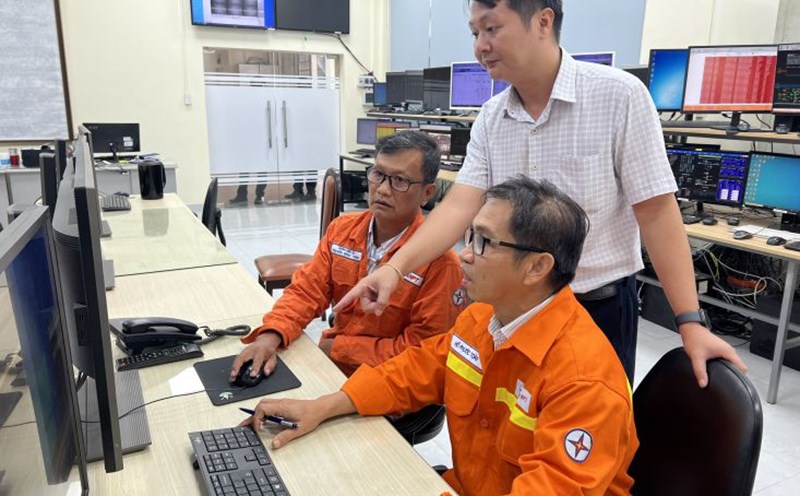 Ông Võ Sỹ Danh (người đứng) hướng dẫn công nhân theo dõi truyền tải điện. Ảnh: Đức Long