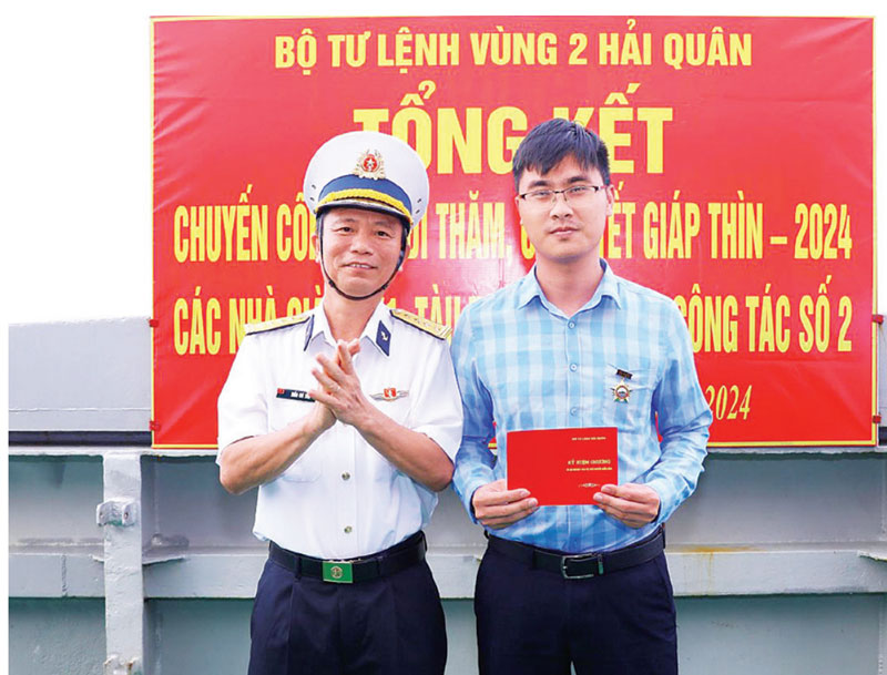 Journalist Tran Tuan was awarded a badge for his homeland's islands and seas during his trip to Truong Sa. Photo: Provided by the character