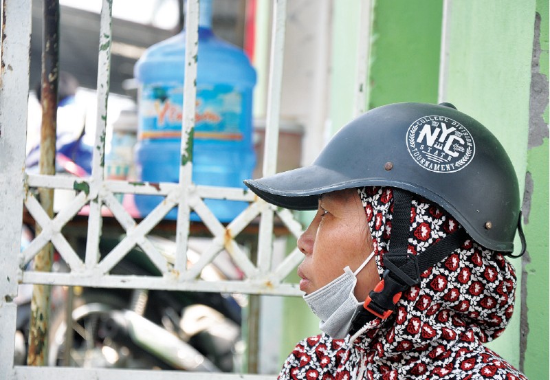 Một nữ công nhân ngồi túc trực tại cổng Công ty TNHH T.T.B Việt Nam MFG (thị xã Việt Yên, tỉnh Bắc Giang).
Ảnh chụp thời điểm tháng 11.2023.	Ảnh: TẤT THẢO
