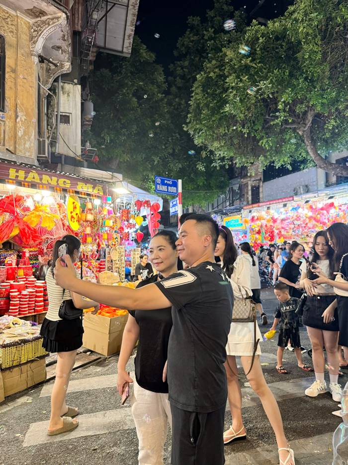 Tourists enjoy checking in with relatives and family on Hang Ma street to preserve memories.