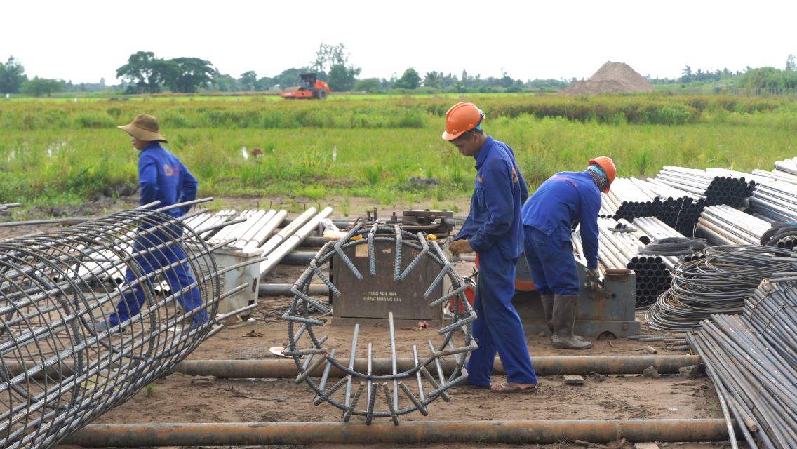 Công nhân miệt mài thi công dưới thời tiết nắng mưa thay đổi thất thường. Ảnh: Tạ Quang