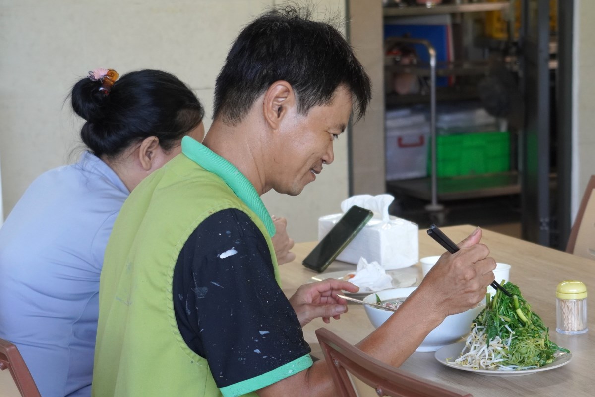 A union member is starting to eat in the happy, comfortable atmosphere of a union meal. Photo: Thanh An