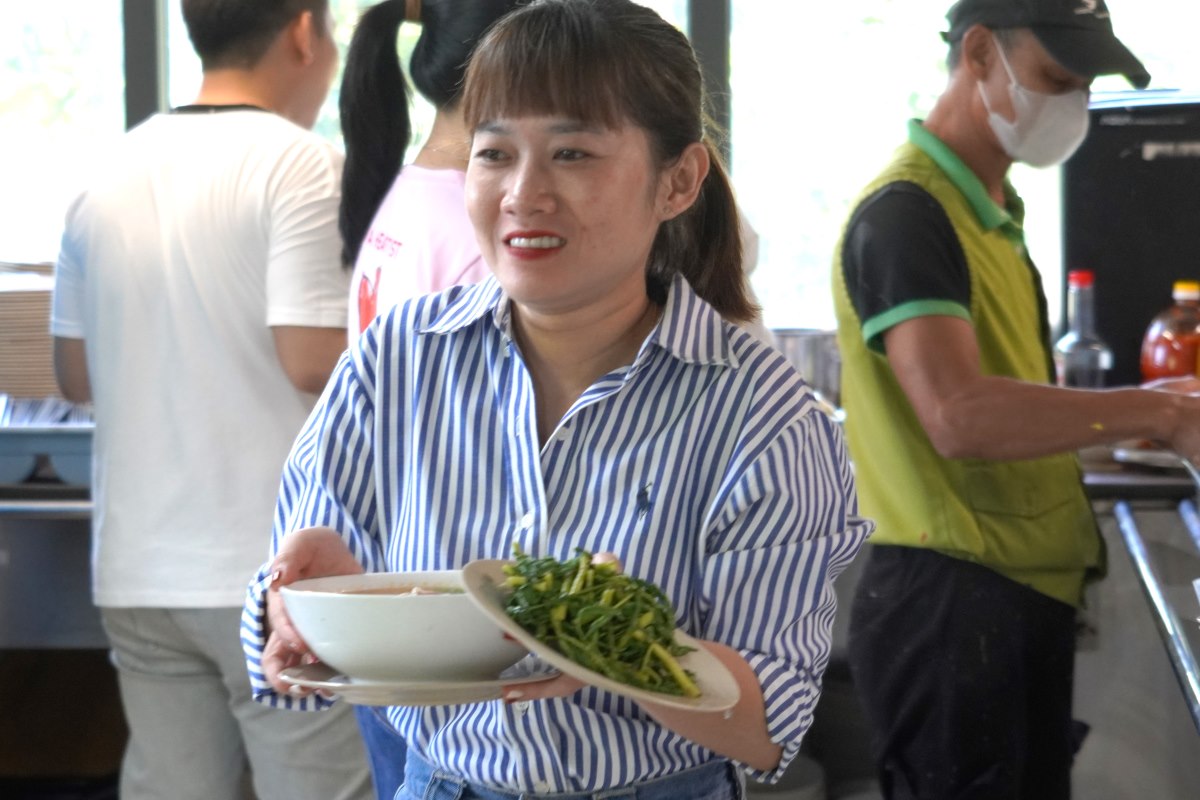 Union member Thuy Lien brought food to the seats to eat. Ms. Lien said the food was delicious, and the meal was very comfortable with her colleagues. Photo: Thanh An.