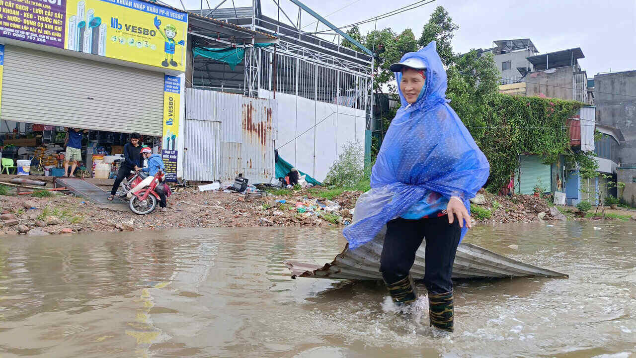 Gió lớn khiến nhiều mái tôn của các hộ dân sinh sống tại khu vực đối diện Chung cư 789 Mỹ Đình (quận Nam Từ Liêm) bị bay mất, nhiều người dân phải lội mưa ngập để tìm về gia cố lại nhà để tiếp tục chống bão. Ảnh: Hải Danh