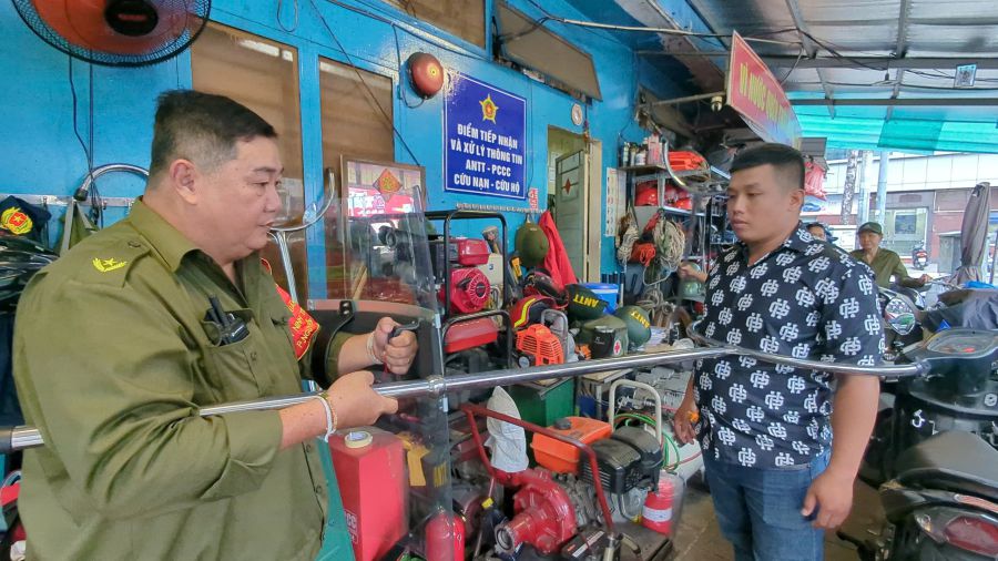 Ông Lý Nhơn Thành (bên trái ảnh) - Chỉ huy lực lượng bảo vệ ANTT phường Nguyễn Thái Bình, Quận 1 chỉ dẫn thành viên sử dụng công cụ bắt tội phạm. 
Ảnh: Anh Tú