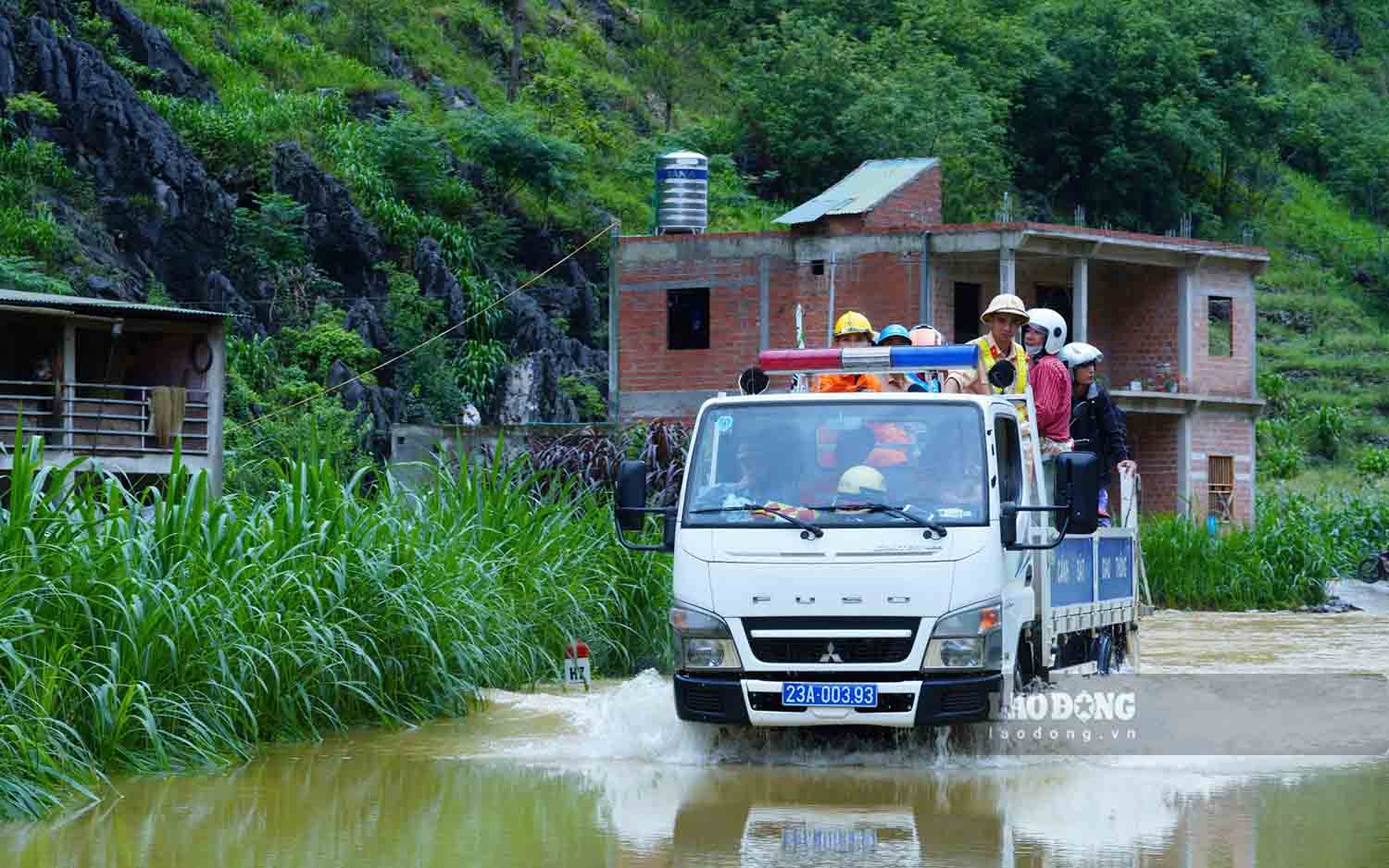 Meo Vac district police help transport people and tourists through flooded areas.