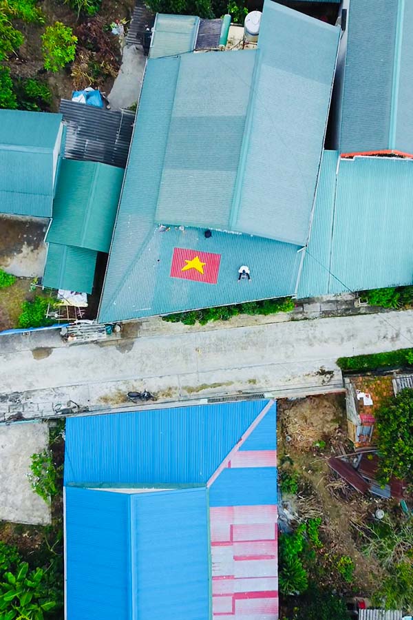 It took Mr. Nguyen Viet Anh about 4 hours to complete the work of the Fatherland flag on the roof. Photo: TH