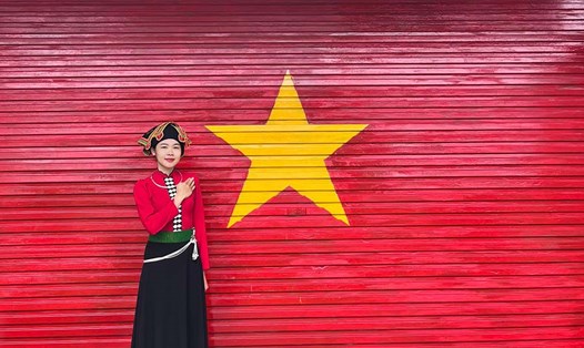 Chị Lò Thị Lan Anh tự hào bên tác phẩm lá cờ Tổ quốc vừa hoàn thiện. Ảnh: TH