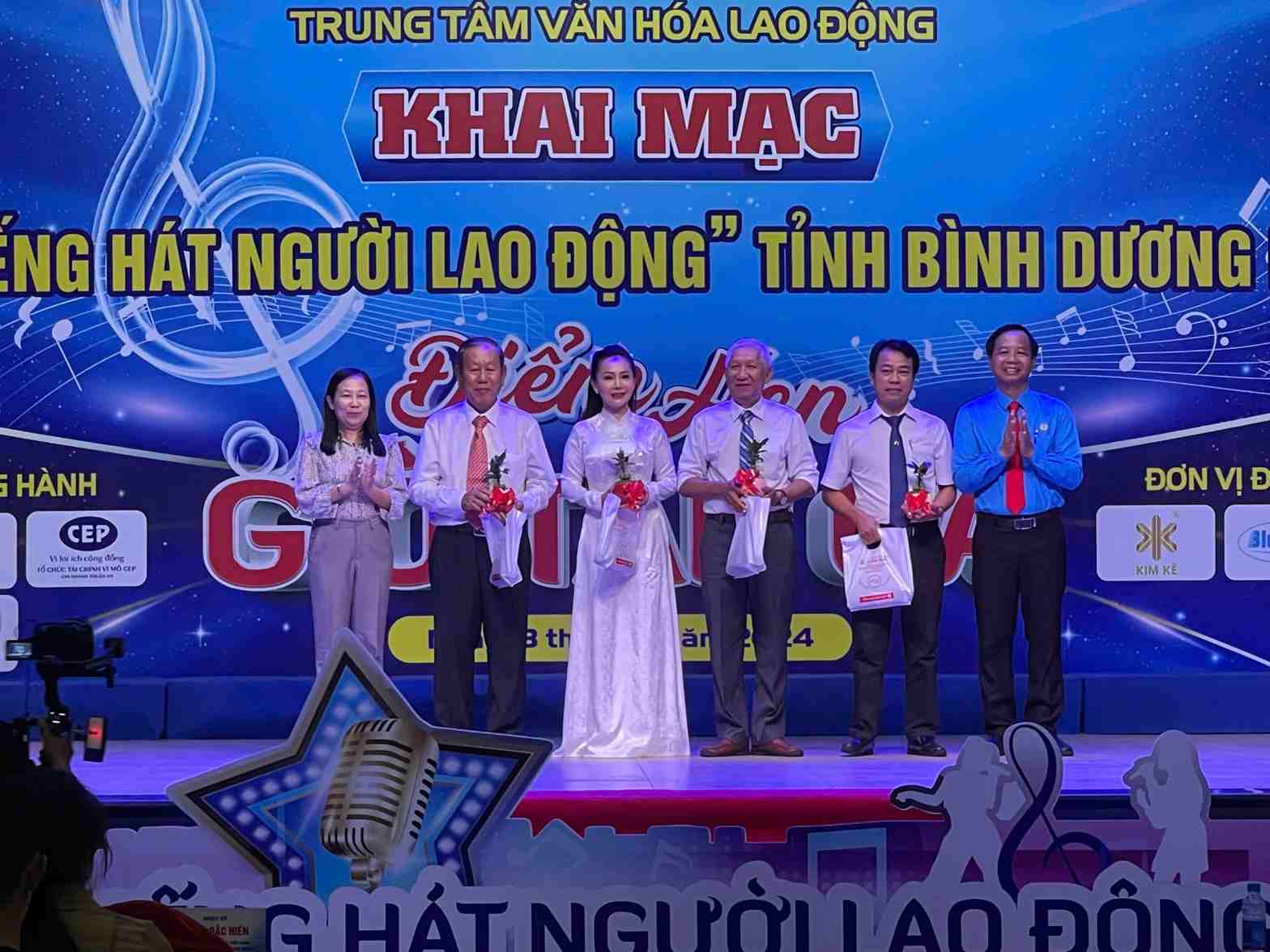 Bà Ong Thụy Hoàng Mai - Phó Chủ tịch LĐLĐ tỉnh Bình Dương và ông Lưu Thế Thuận - Trưởng Ban Tuyên giáo - Nữ công LĐLĐ tỉnh tặng hoa cảm ơn Ban giám khảo. Ảnh: CĐBD