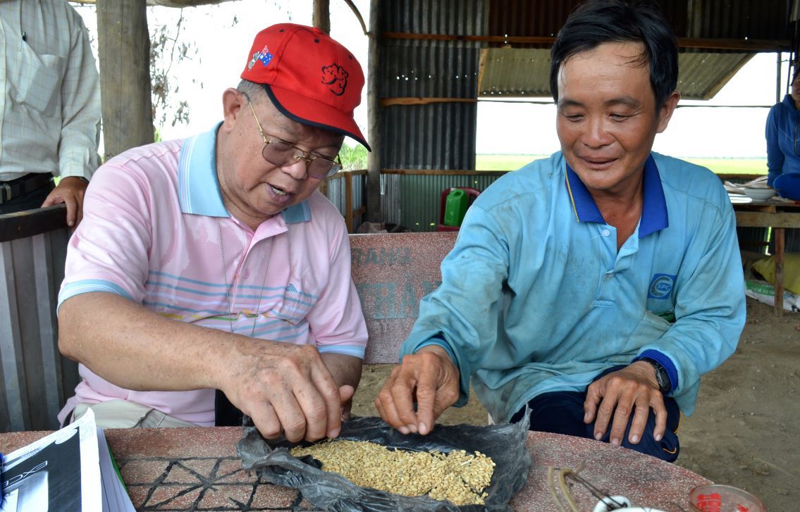 Giáo sư Võ Tòng Xuân trong lần đi thực tế tại cánh đồng Tứ giác Long Xuyên đã ghé thăm và thân mật trò chuyên cùng nông dân trồng lúa. Ảnh: Lục Tùng