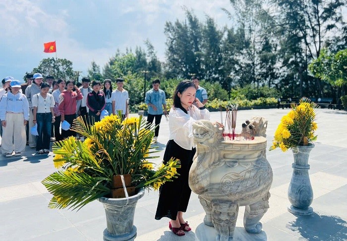 Bà Bùi Thị Ngọc Linh - Chủ tịch Công đoàn Cơ sở Công ty Cổ phần Cao su Đắk Lắk cùng các em học sinh, sinh viên dâng hương tại Khu tưởng niệm chiến sĩ Gạc Ma. Ảnh: Bảo Trung