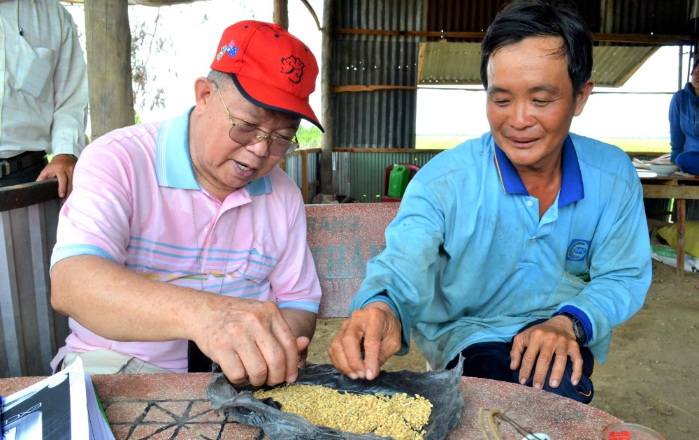 Giáo sư Võ Tòng Xuân trong lần đi thực tế tại cánh đồng Tứ giác Long Xuyên đã ghé thăm và thân mật trò chuyện cùng nông dân trồng lúa. Ảnh: Lục Tùng