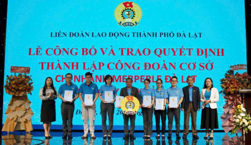 Ông Hoàng Liên - Chủ tịch Liên đoàn Lao động tỉnh Lâm Đồng (thứ hai bìa phải) trao quyết định kết nạp đoàn viên và huy hiệu công đoàn cho Ban Chấp hành công đoàn cơ sở. Ảnh: A.TÚ