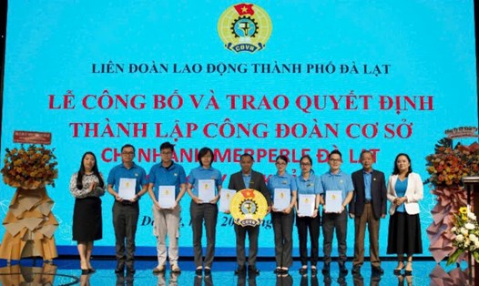 Ông Hoàng Liên - Chủ tịch Liên đoàn Lao động tỉnh Lâm Đồng (thứ hai bìa phải) trao quyết định kết nạp đoàn viên và huy hiệu công đoàn cho Ban Chấp hành công đoàn cơ sở. Ảnh: A.TÚ