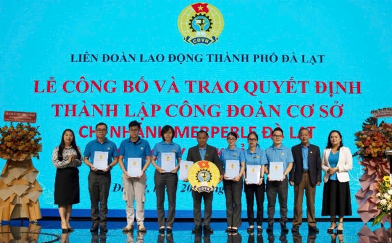Ông Hoàng Liên - Chủ tịch Liên đoàn Lao động tỉnh Lâm Đồng (thứ hai bìa phải) trao quyết định kết nạp đoàn viên và huy hiệu công đoàn cho Ban Chấp hành công đoàn cơ sở. Ảnh: A.TÚ