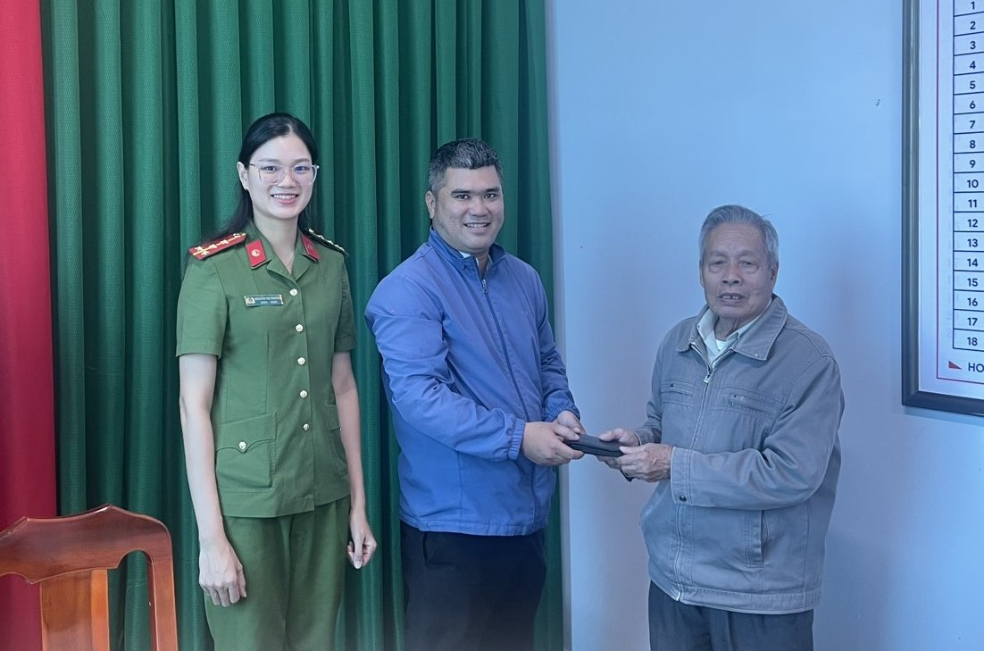 Cụ ông Phạm Xuân Tuệ trao trả lại ví tiền cho người đánh rơi. Ảnh: Phan Tuấn