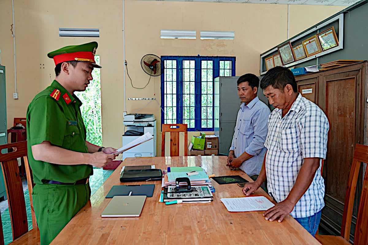 Công an tống đạt Quyết định khởi tố 2 bị can nhưng cho tại ngoại, cấm đi khỏi nơi cư trú. Ảnh: Phạm Duy 