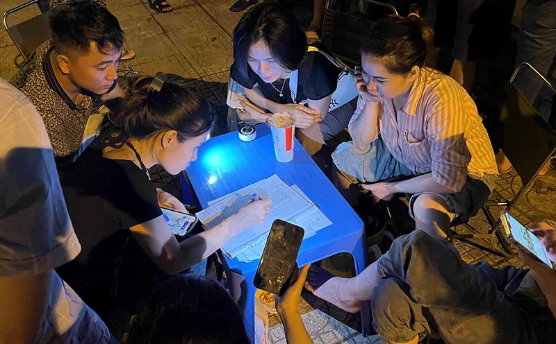 Một nhóm người ngồi tổng hợp kết quả đấu giá đất, bàn phương án bỏ giá như thế nào trong cuộc đấu giá ngày 19.8. Ảnh: Anh Quân
