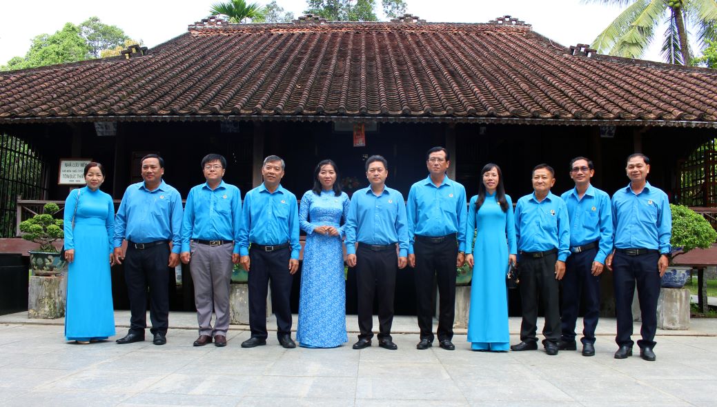 The delegation of the Labor Confederation of An Giang province took souvenir photos in front of Uncle Ton's boyhood house located within the grounds of the Special National Monument. Photo: Luc Tung