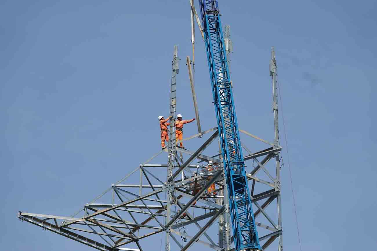 Công nhân đang thi công lắp dựng phần đỉnh của cột số 8 ở xã Kỳ Nam, thị xã Kỳ Anh thuộc dự án 500kV mạch 3. Ảnh: Trần Tuấn.