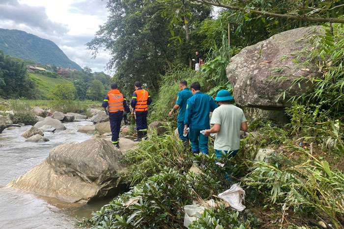 Lực lượng chức năng tìm kiếm người mất tích dọc bờ suối. Ảnh: Đinh Đại