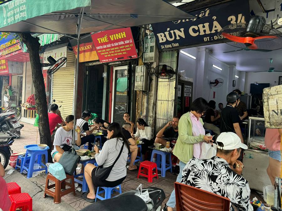 The unique "sidewalk" bun cha restaurant on Hang Than street is still crowded with customers.