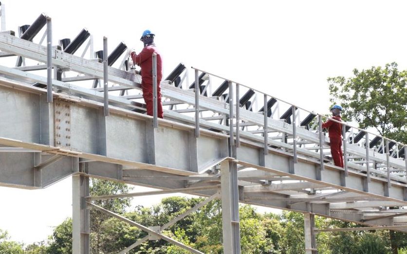 Contractor workers focus on completing the final parts of the conveyor system.