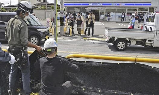 Công nhân dựng một màn chắn đen khổng lồ trên một đoạn vỉa hè tại thị trấn Fujikawaguchiko, tỉnh Yamanashi, Nhật Bản vào ngày 21.5 để chặn tầm nhìn ra Núi Phú Sĩ. Ảnh: Kyodo News