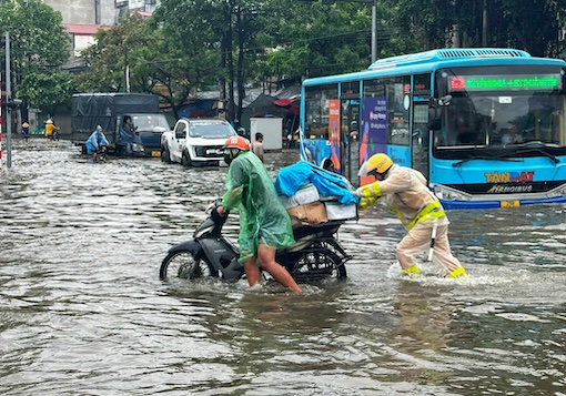 Các phương tiện giao thông đi lại khó khăn trong tình trạng nước dâng cao. Ảnh: Tô Thế. 